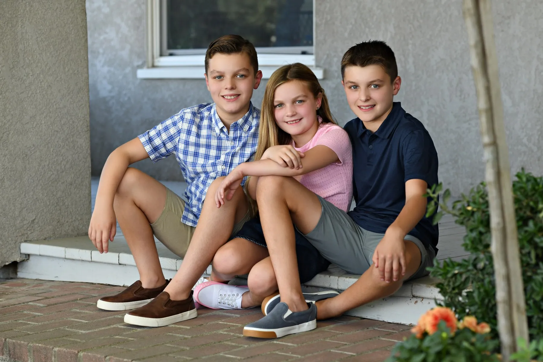Baron, Ellis, and Blythe sitting together on the front porch steps