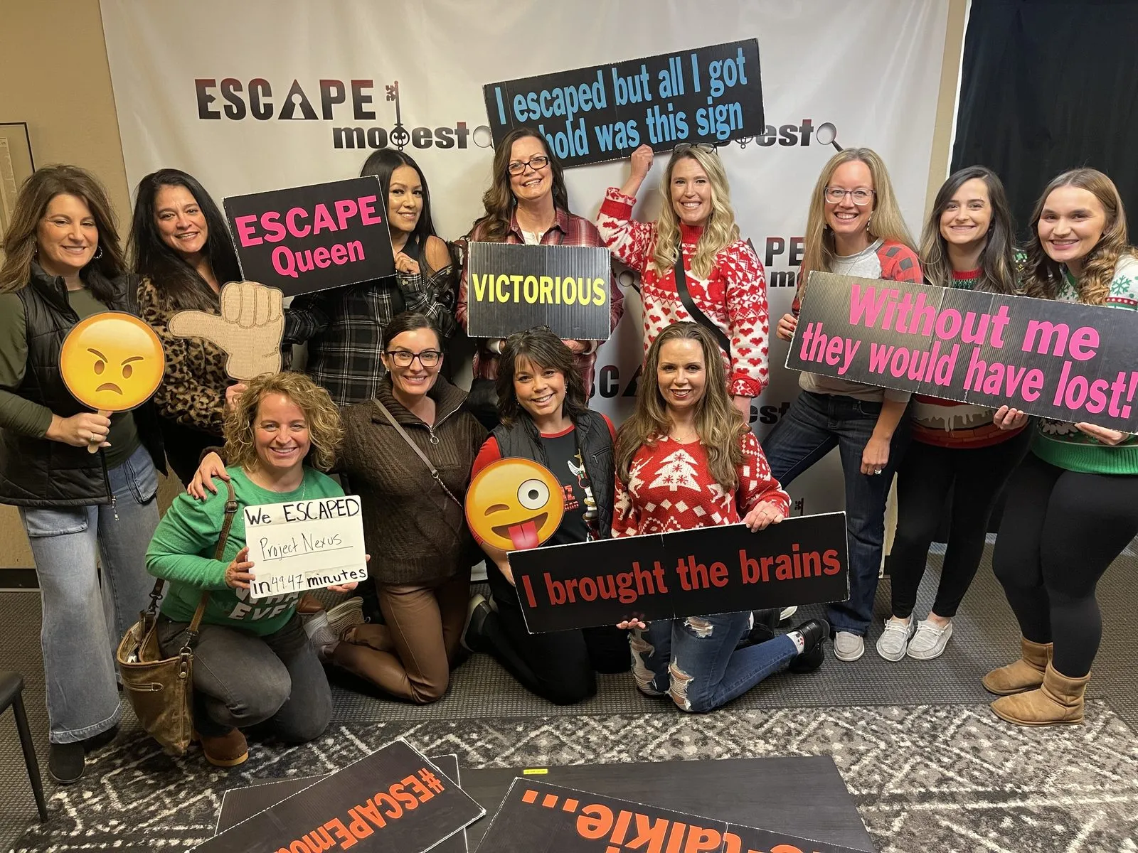 Dr. Kaci Kuykendall and her dental team posing with novelty signs after finishing an escape room together
